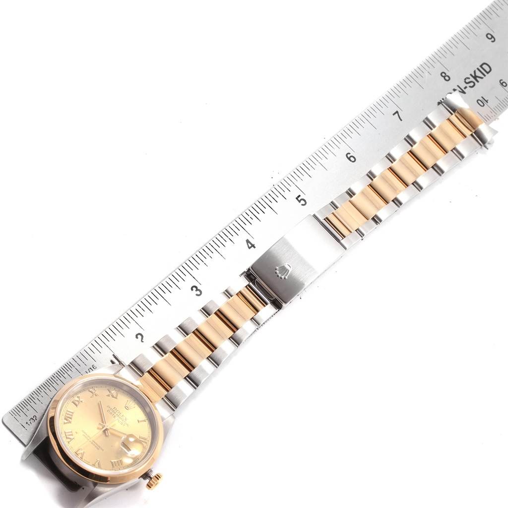 A top-down view of a Rolex Datejust 16203 Men's Steel and Gold (two tone) Champagne Dial 16203 Men's Steel and Gold (two tone) Champagne Dial watch, showing its face, band, and clasp alongside a ruler for size reference.