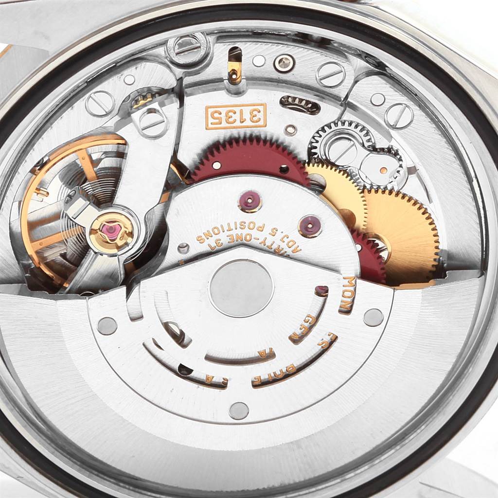 The image shows an internal view of the Rolex Datejust 16233 Men
s Steel and Gold (two tone) White Dial 16233 Men
s Steel and Gold (two tone) White Dial watch movement, highlighting gears and components from a top-down angle.