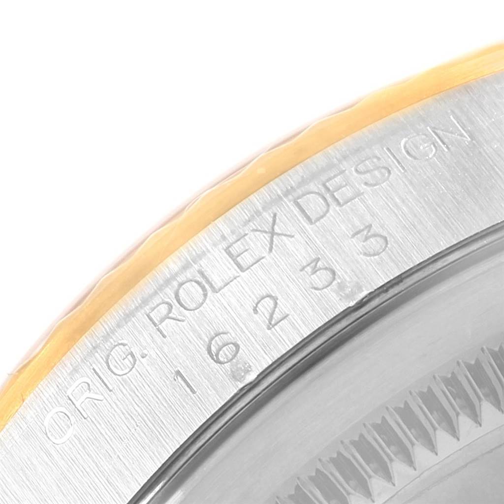 The image shows a close-up of the bezel and part of the case of a Rolex Datejust 16233 Men
s Steel and Gold (two tone) White Dial 16233 Men
s Steel and Gold (two tone) White Dial watch.