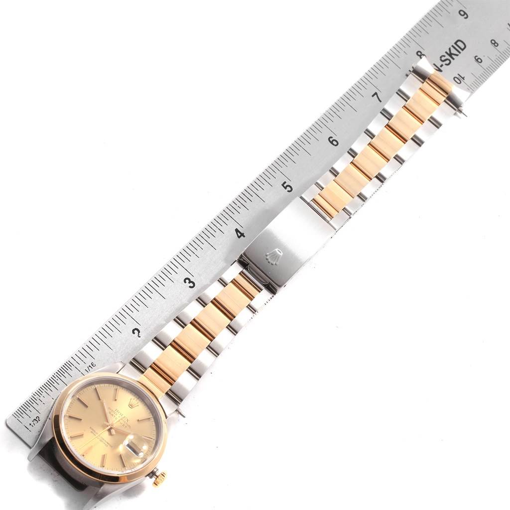 The image shows a Rolex Datejust 19885 Men's Steel and Gold (two tone) Champagne Dial 19885 Men's Steel and Gold (two tone) Champagne Dial watch horizontally aligned next to a ruler, highlighting its band and clasp.