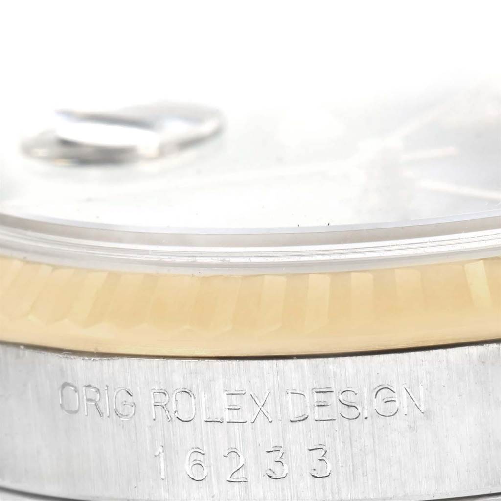 This close-up image of a Rolex Datejust 16233 Men's Steel and Gold (two tone) Beige Dial 16233 Men's Steel and Gold (two tone) Beige Dial watch shows the edge of the dial, the bezel, and the engraved model number 16233.