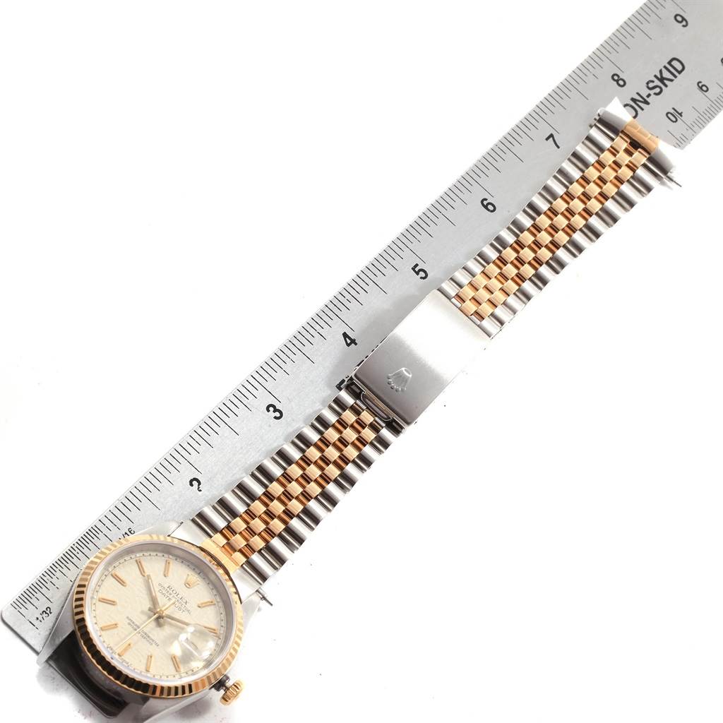 This image shows a Rolex Datejust 16233 Men's Steel and Gold (two tone) Beige Dial 16233 Men's Steel and Gold (two tone) Beige Dial watch laid flat with a two-tone bracelet alongside a ruler for measurement.
