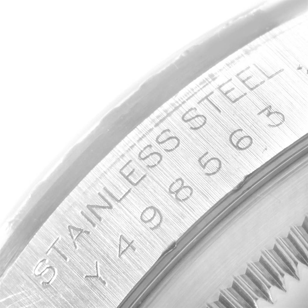 The image shows a close-up of the Rolex Datejust 16220 Men
s Stainless Steel Silver Dial 16220 Men
s Stainless Steel Silver Dial
s case edge with the "Stainless Steel" engraving and part of the serial number.