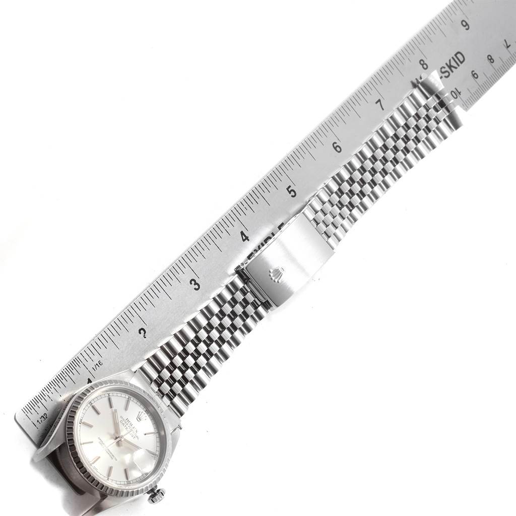 The image shows the Rolex Datejust 16220 Men
s Stainless Steel Silver Dial 16220 Men
s Stainless Steel Silver Dial watch from an overhead angle, highlighting its face, bezel, crown, and metal bracelet with a clasp.
