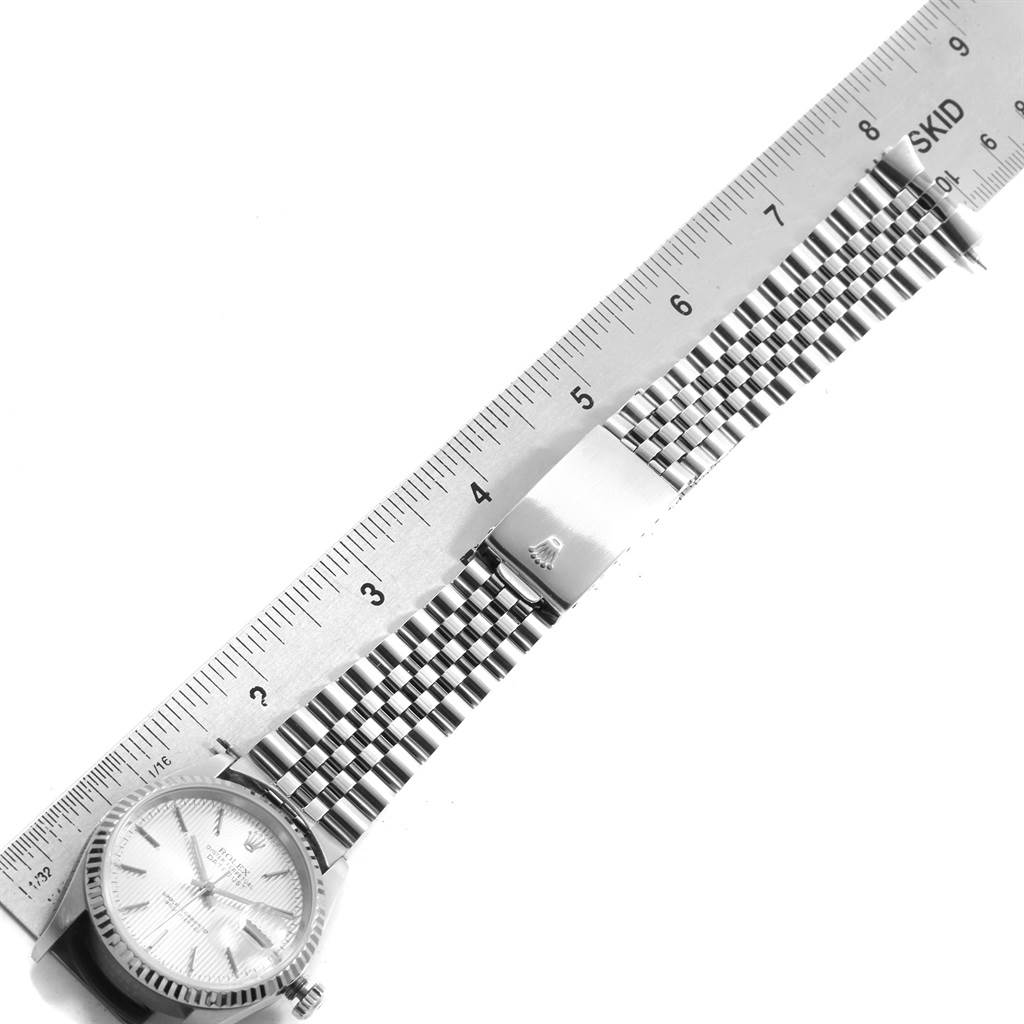 The image shows a top-down view of a Rolex Datejust 16234 Men's Stainless Steel Silver Dial 16234 Men's Stainless Steel Silver Dial watch, highlighting the face, bracelet, and clasp alongside a ruler for scale.