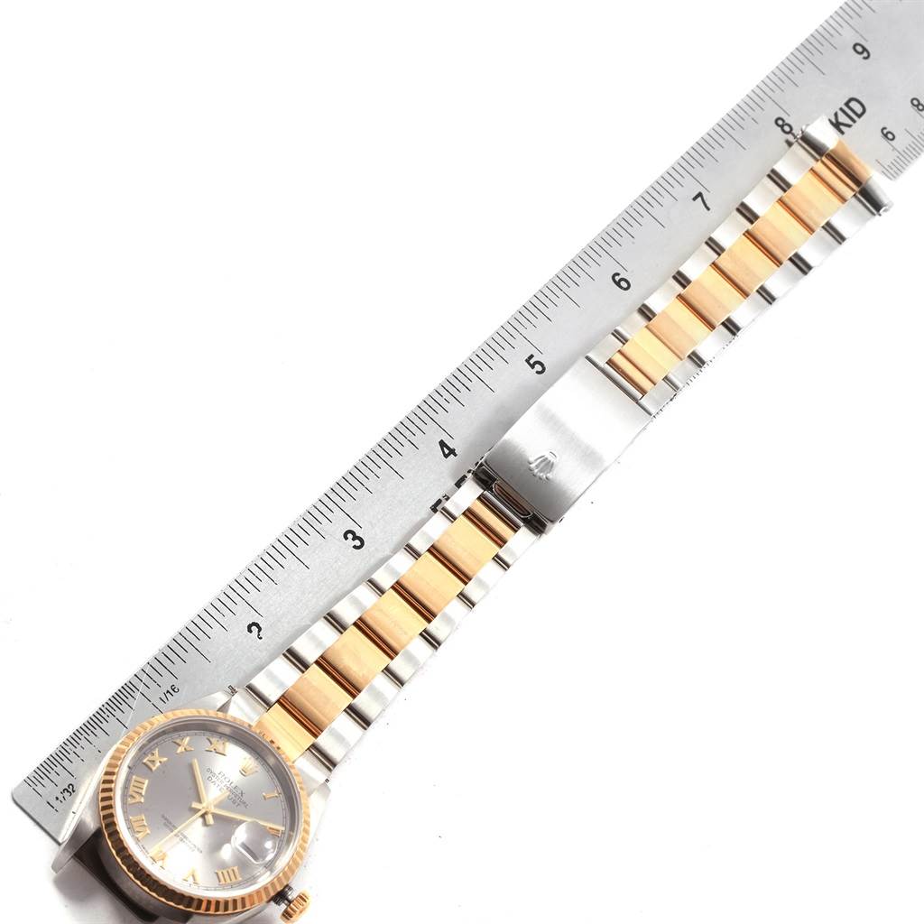 The image shows a Rolex Datejust 20208 Men
s Steel and Gold (two tone) Grey Dial 20208 Men
s Steel and Gold (two tone) Grey Dial watch, focusing on its face, bezel, and two-tone bracelet, alongside a ruler for measuring.