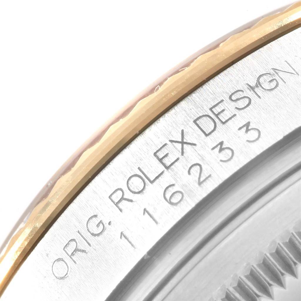 This close-up image shows part of the bezel and inscription on the case of a Rolex Datejust 116233 Men's Stainless Steel Champagne Dial 116233 Men's Stainless Steel Champagne Dial model.