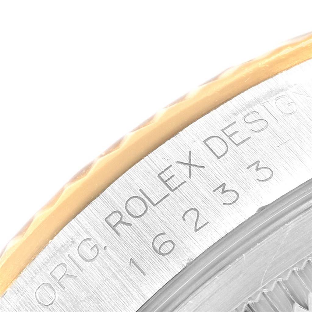 The image shows a close-up of the Rolex Datejust 16233 Men
s Steel and Gold (two tone) Black Dial 16233 Men
s Steel and Gold (two tone) Black Dial model, highlighting the engraved bezel and edge of the watch case.