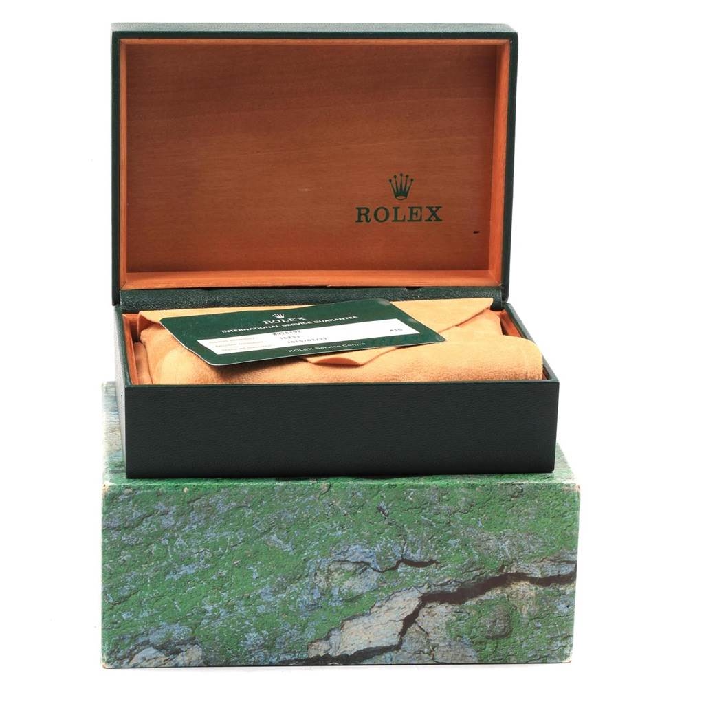 This image shows an open green Rolex box containing a Datejust model, with an authenticity card on top.