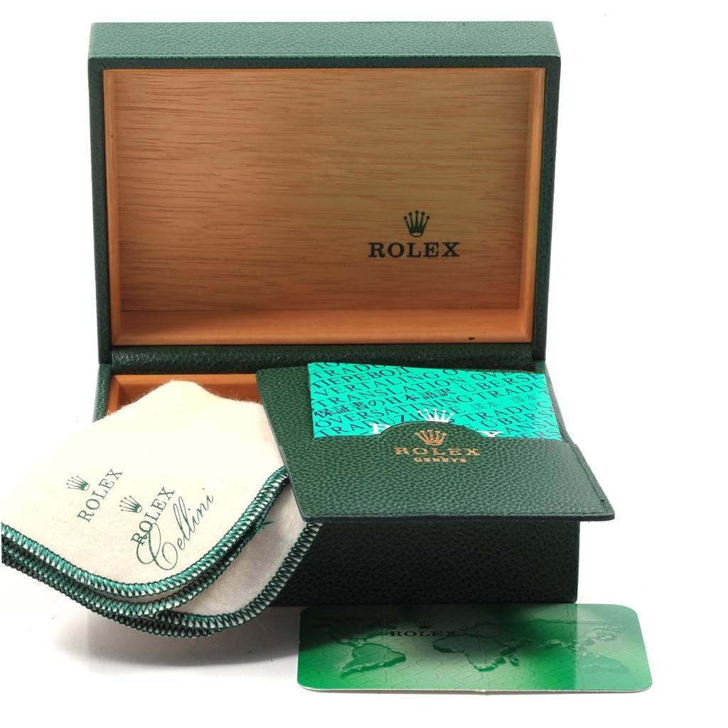 The image shows an open Rolex box with accessories, including a cleaning cloth, cardholder, and paperwork for the Datejust model.
