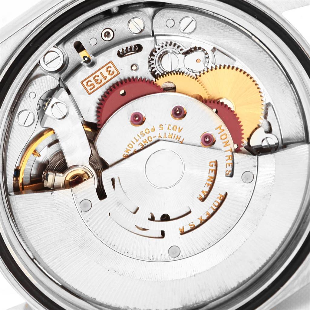 The image shows the internal mechanism of a Rolex Datejust 16233 Men's Steel and Gold (two tone) White Dial 16233 Men's Steel and Gold (two tone) White Dial watch, highlighting its intricate gears and parts.