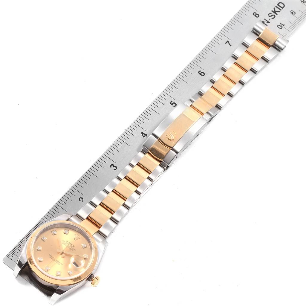 The Rolex Datejust 116203 Men's Stainless Steel Champagne Dial 116203 Men's Stainless Steel Champagne Dial watch is shown flat, displaying the face, bezel, and entire bracelet with a ruler for scale.