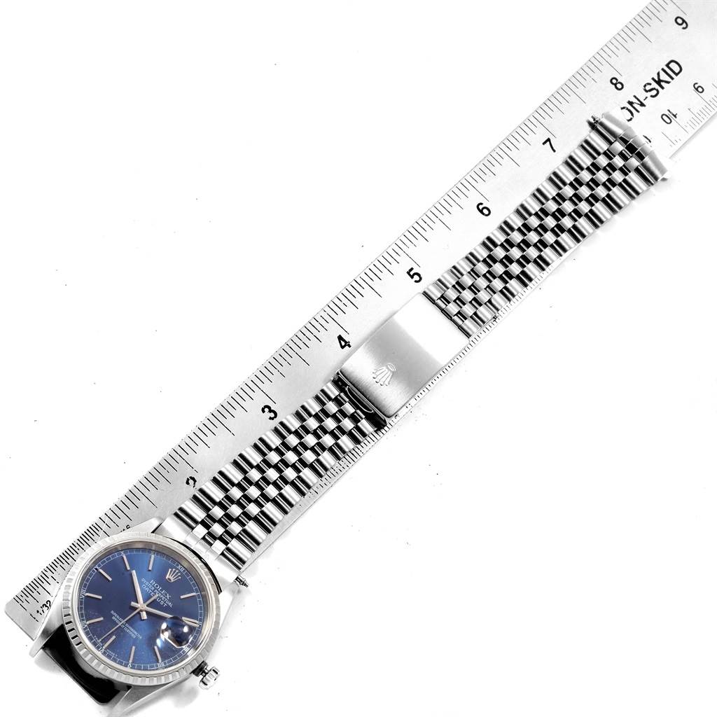 The Rolex Datejust 16220 Men
s Stainless Steel Blue Dial 16220 Men
s Stainless Steel Blue Dial watch is shown flat with a ruler measuring its Jubilee bracelet and clasp.