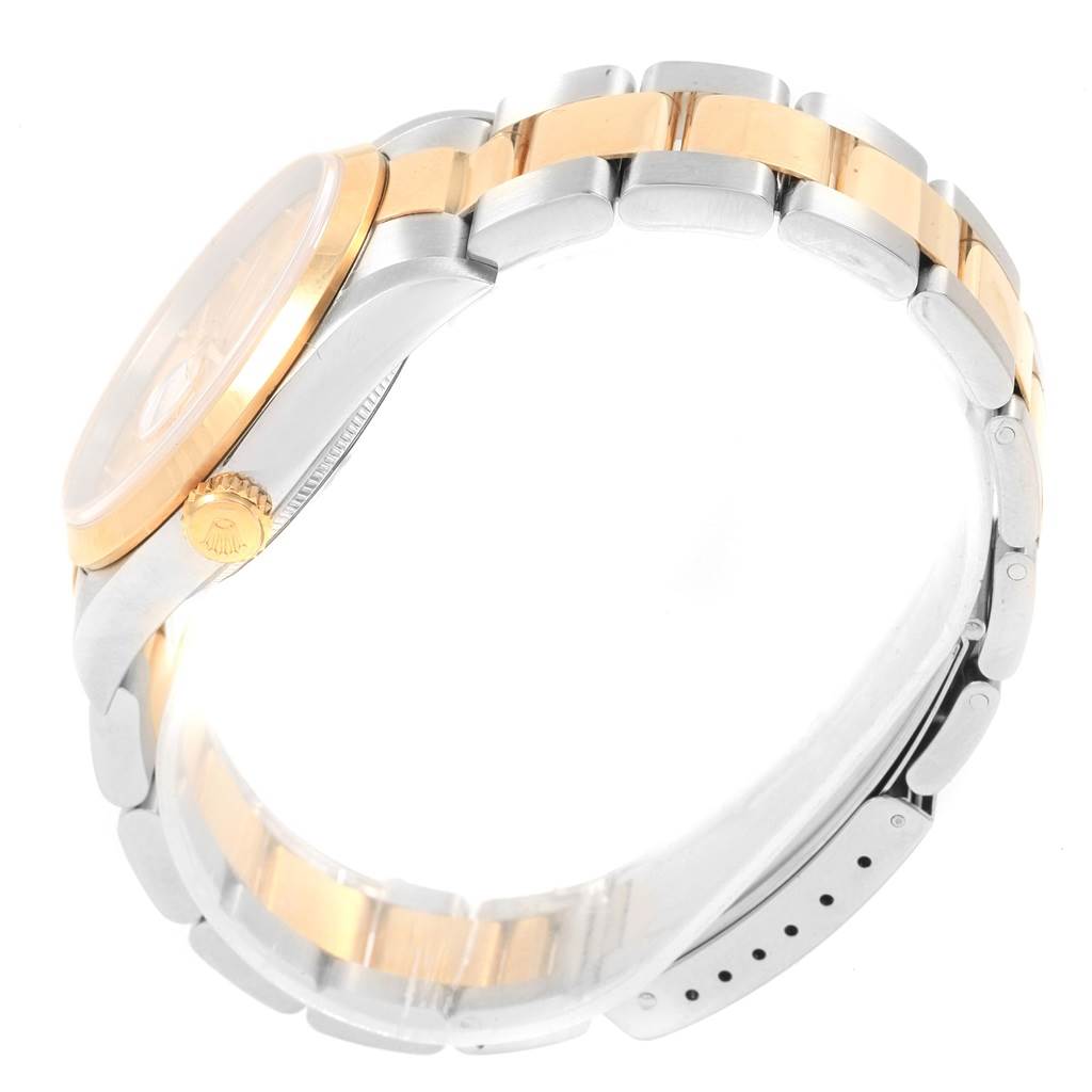 The Rolex Datejust 20413 Men's Steel and Gold (two tone) Champagne Dial 20413 Men's Steel and Gold (two tone) Champagne Dial watch is shown from a side angle, displaying the crown, bezel, and part of the two-tone bracelet.
