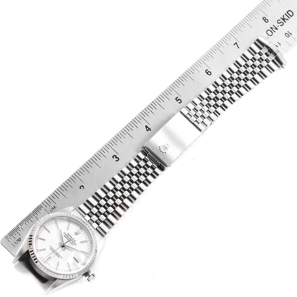The image shows a Rolex Datejust 16234 Men's Stainless Steel White Dial 16234 Men's Stainless Steel White Dial watch with a metal bracelet and deployant clasp, positioned beside a metal ruler for measurement.