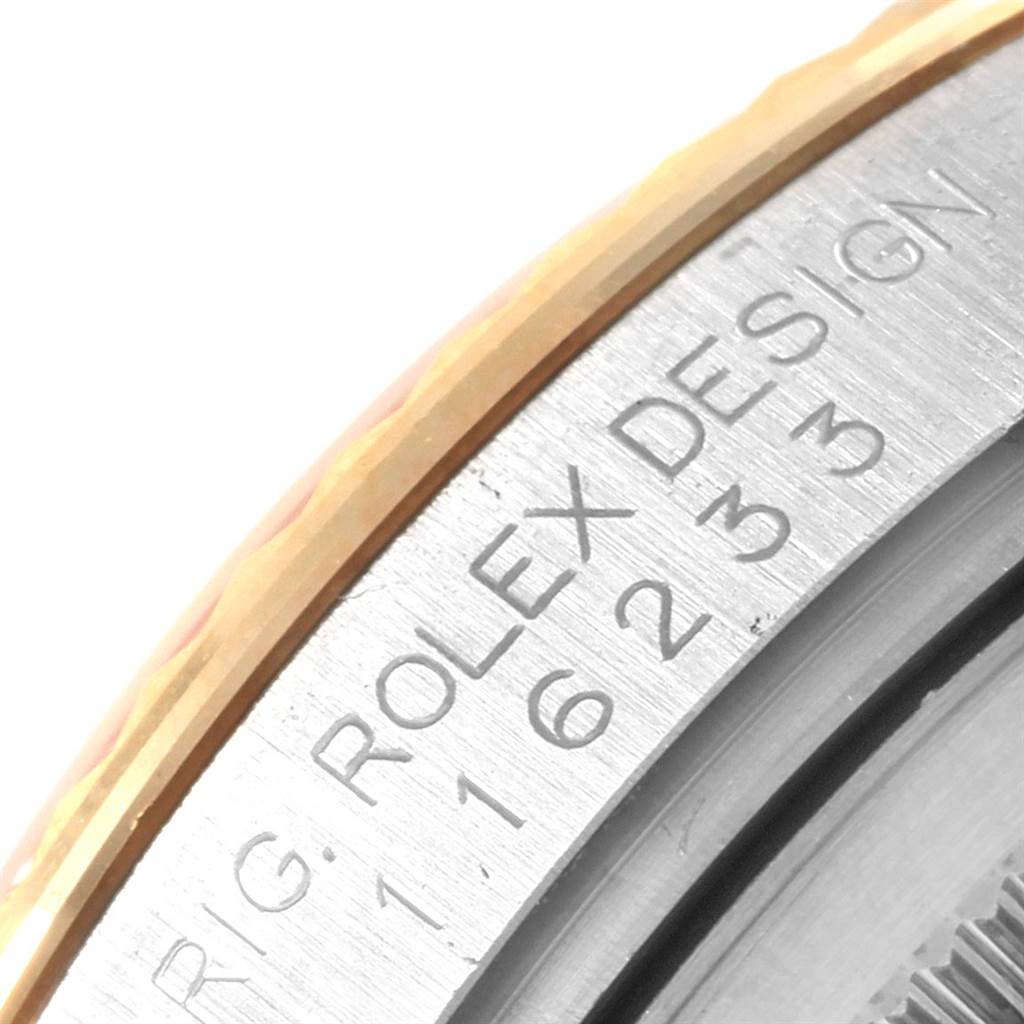 This close-up image shows the engraved side of the bezel of a Rolex Datejust 116233 Men's Steel and Gold (two tone) Champagne Dial 116233 Men's Steel and Gold (two tone) Champagne Dial watch.