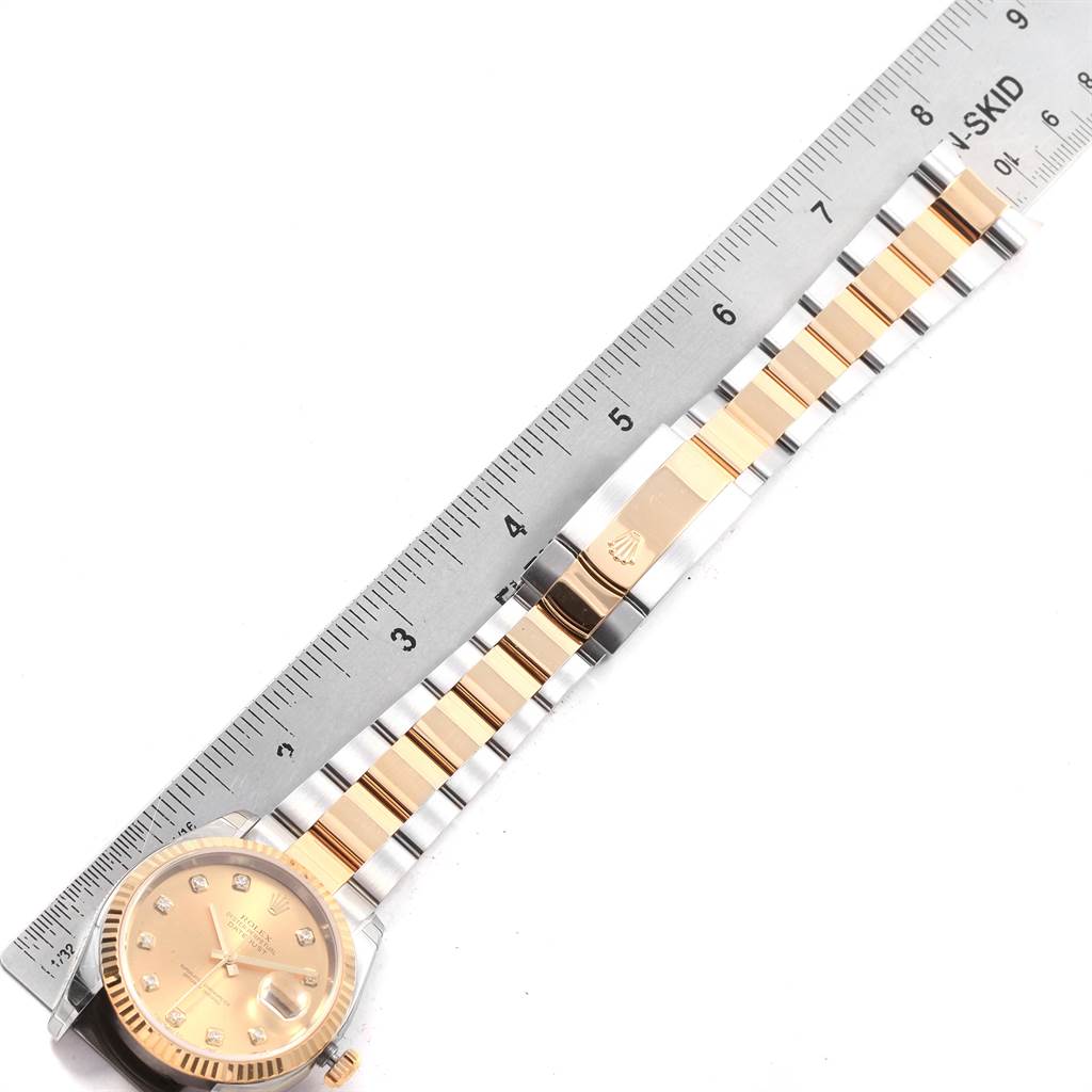 The image shows a Rolex Datejust 116233 Men's Steel and Gold (two tone) Champagne Dial 116233 Men's Steel and Gold (two tone) Champagne Dial watch lying flat next to a ruler, displaying the face and bracelet.