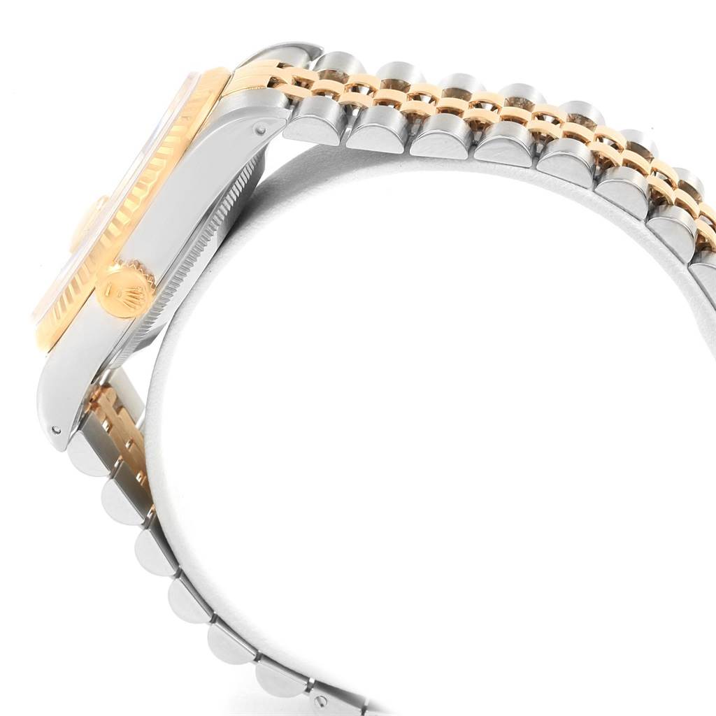 The image shows a close-up side view of a Rolex Datejust 16233 Men's Steel and Gold (two tone) Champagne Dial 16233 Men's Steel and Gold (two tone) Champagne Dial watch, highlighting the gold crown, fluted bezel, and silver-and-gold Jubilee bracelet.