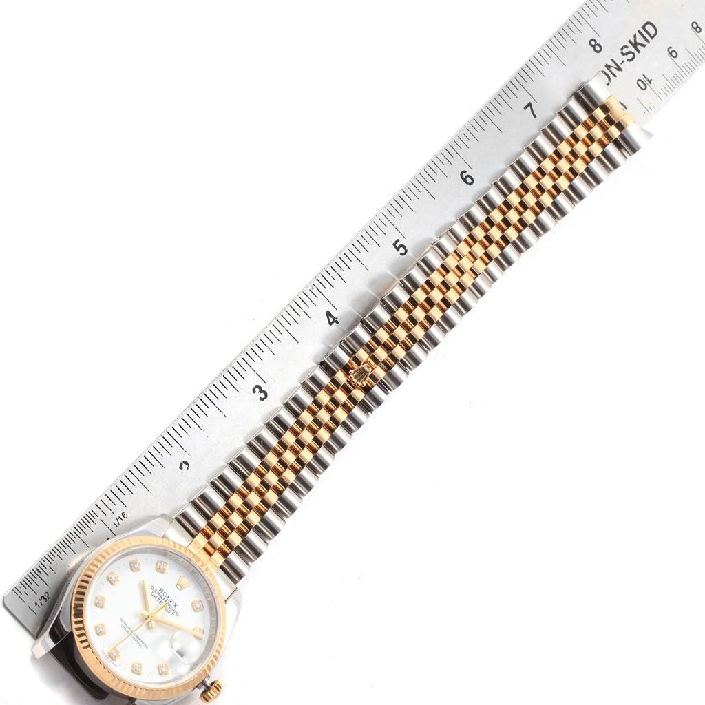 The image shows a Rolex Datejust 116233 Men's Stainless Steel White Dial 116233 Men's Stainless Steel White Dial watch laying flat with its dial and bracelet partially visible, alongside a ruler.