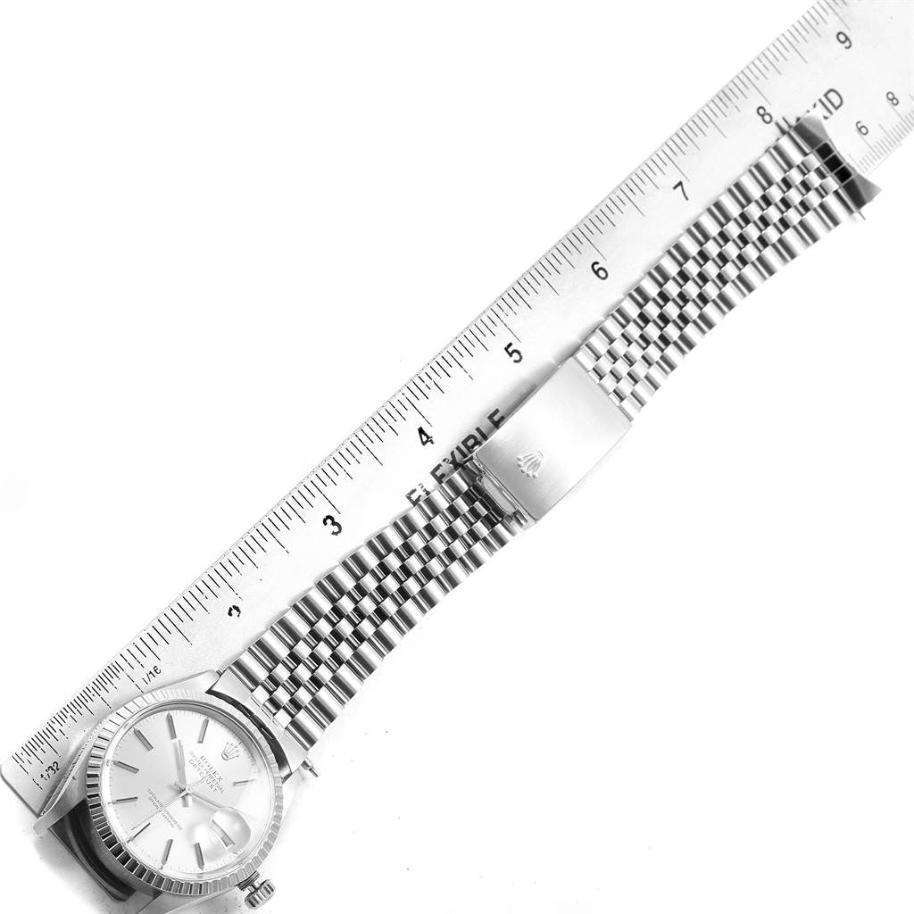 This image shows a Rolex Datejust 16030 Men
s Stainless Steel Silver Dial 16030 Men
s Stainless Steel Silver Dial watch with its stainless steel bracelet, laid flat alongside a ruler for measurement.
