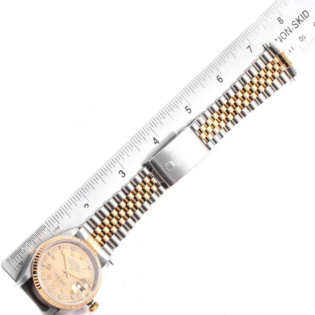 The Rolex Datejust 16233 Men's Steel and Gold (two tone) Champagne Dial 16233 Men's Steel and Gold (two tone) Champagne Dial watch is photographed from above, showcasing the face, dial, crown, and metal bracelet, with a ruler for scale.