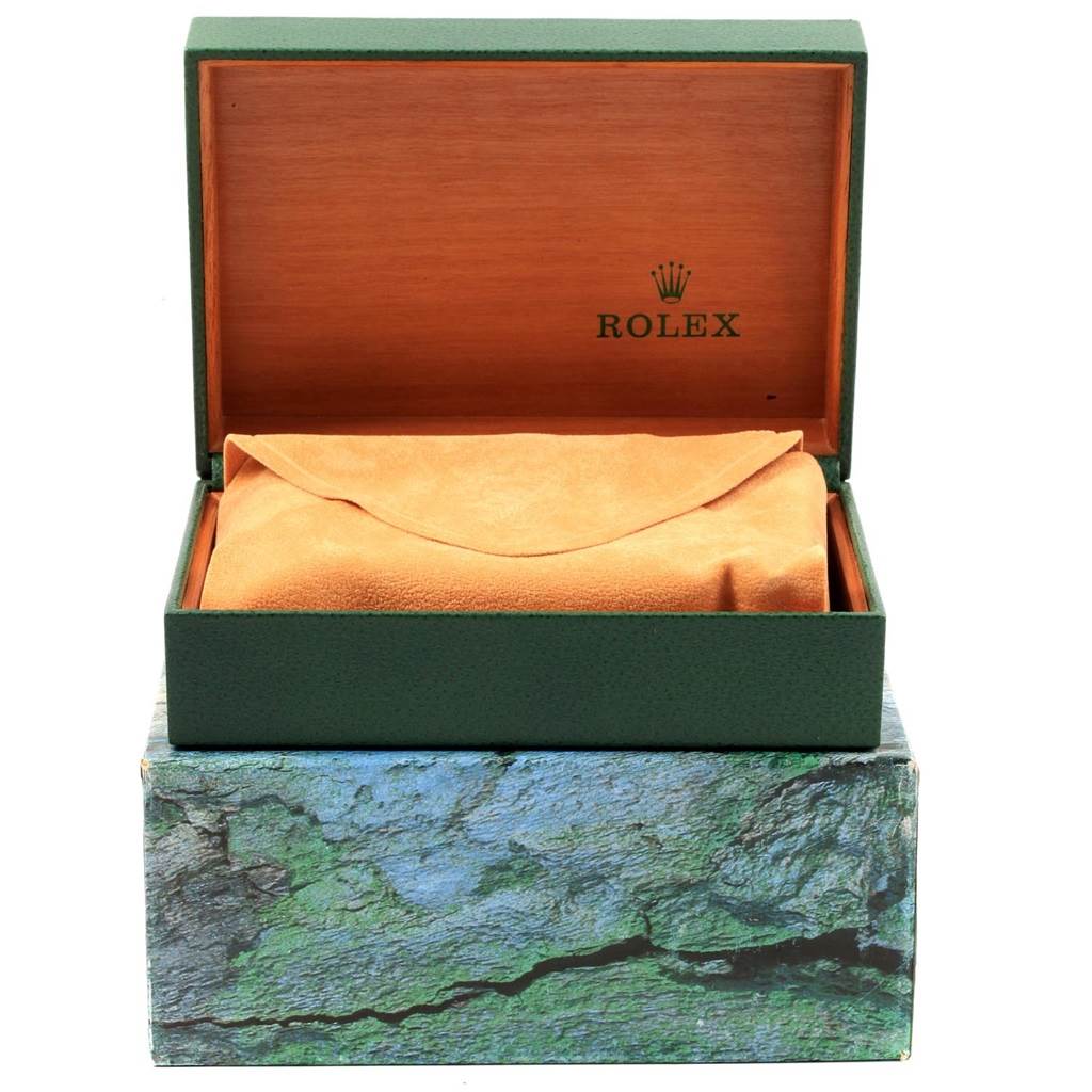 The image shows an open Rolex Datejust 16233 Men's Steel and Gold (two tone) Champagne Dial 16233 Men's Steel and Gold (two tone) Champagne Dial watch box, displaying the inner green and wooden layers and a wrapped item inside.