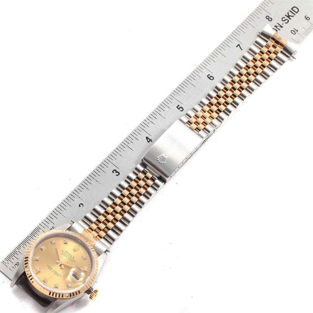 The image shows an overhead view of a Rolex Datejust 16233 Men's Steel and Gold (two tone) Champagne Dial 16233 Men's Steel and Gold (two tone) Champagne Dial watch, highlighting its dial, bezel, and Jubilee bracelet next to a ruler.