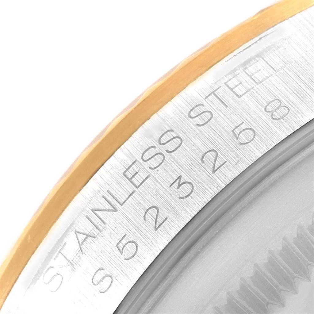 This is a close-up image of the bezel and part of the case back of a Rolex Datejust 16233 Men's Steel and Gold (two tone) Champagne Dial 16233 Men's Steel and Gold (two tone) Champagne Dial watch, showing "STAINLESS STEEL" engraving.