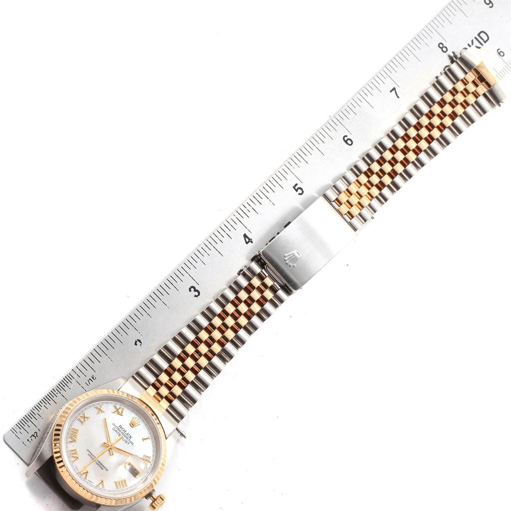 The image shows a Rolex Datejust 16233 Men's Steel and Gold (two tone) Mother of Pearl Dial 16233 Men's Steel and Gold (two tone) Mother of Pearl Dial watch laying flat with its bracelet extended, alongside a ruler for scale.