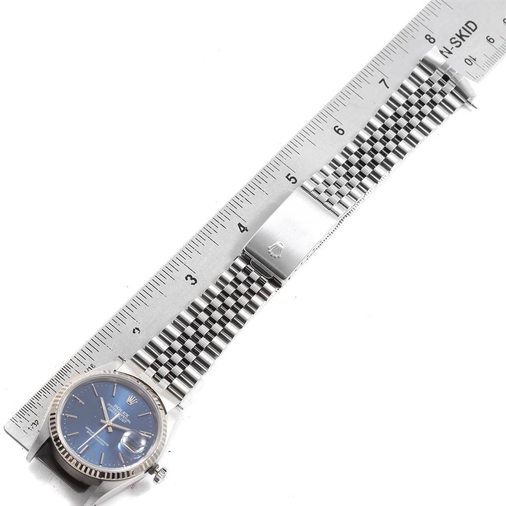 The image shows a Rolex Datejust 16234 Men's Stainless Steel Blue Dial 16234 Men's Stainless Steel Blue Dial watch from an overhead angle, displaying the dial, bezel, bracelet, and clasp along a ruler for scale.