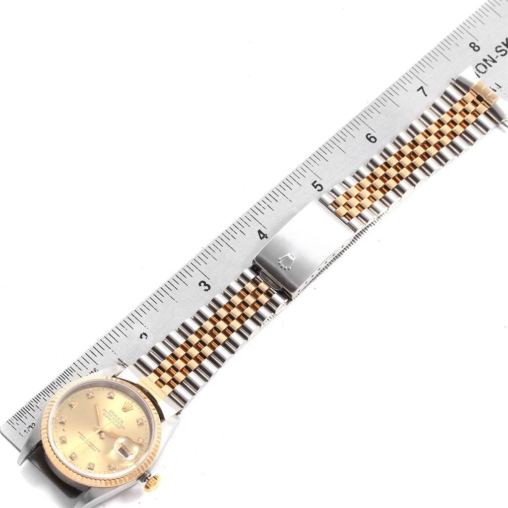 The image shows a top-down view of a Rolex Datejust 16233 Men's Steel and Gold (two tone) Champagne Dial 16233 Men's Steel and Gold (two tone) Champagne Dial watch, highlighting its face, bracelet, and clasp with a ruler for scale.