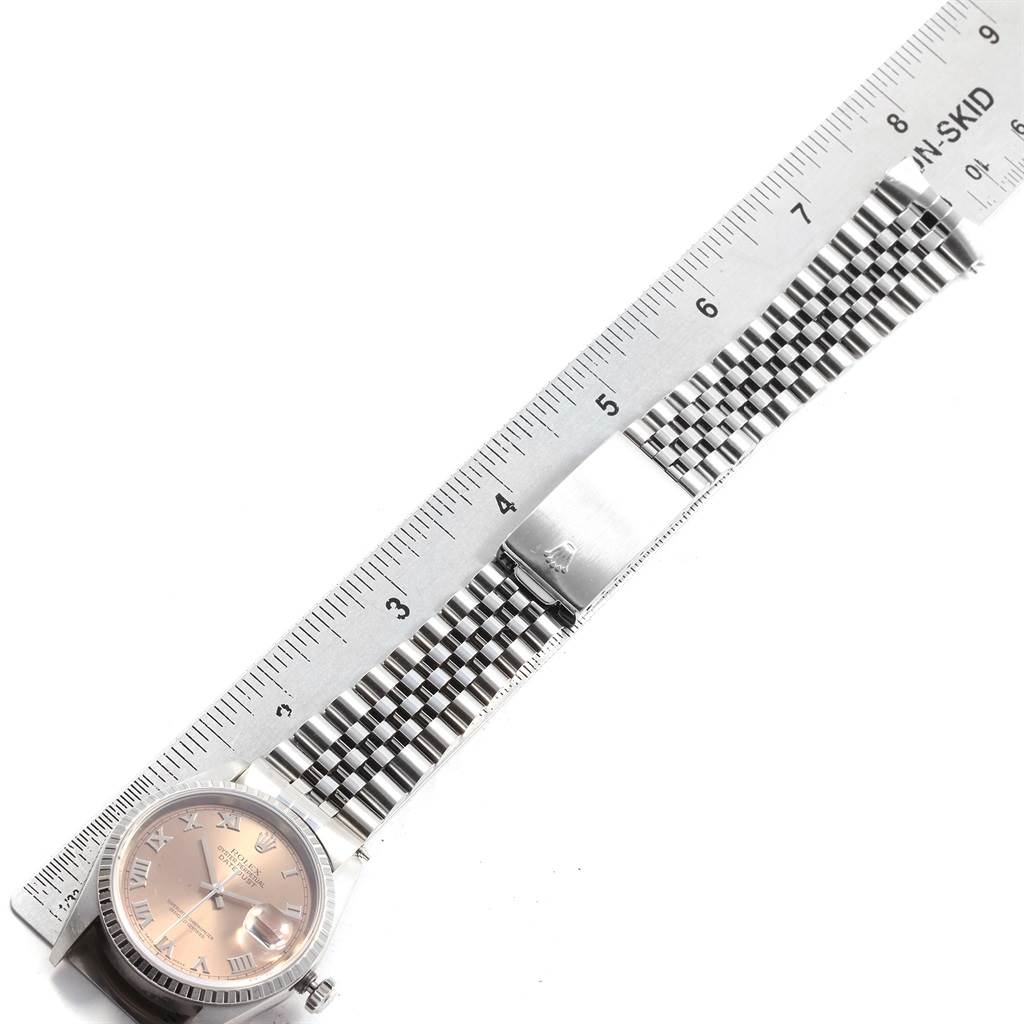 The image shows a Rolex Datejust 16220 Men's Stainless Steel Pink Dial 16220 Men's Stainless Steel Pink Dial watch laying flat with its bracelet extended alongside a ruler for scale.