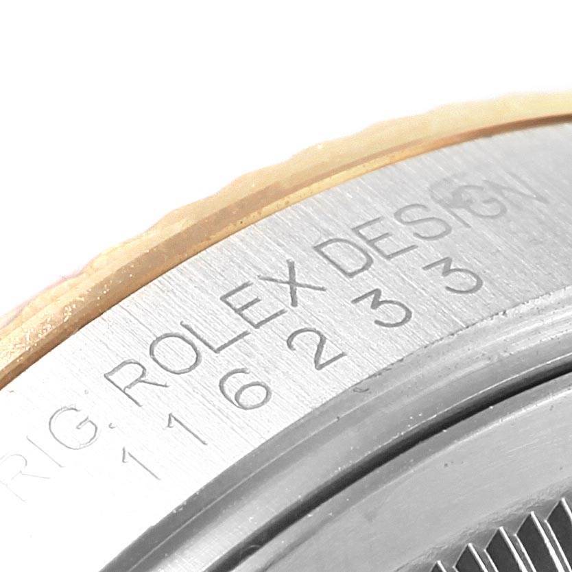 This close-up shows the side of a Rolex Datejust 116233 Men's Stainless Steel Silver Dial 116233 Men's Stainless Steel Silver Dial watch with the model number and "ROLEX DESIGN" engraving.
