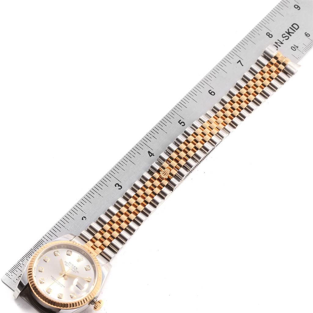 The image shows a top-down view of a Rolex Datejust 116233 Men's Stainless Steel Silver Dial 116233 Men's Stainless Steel Silver Dial watch with its dial, bezel, and bracelet alongside a ruler for scale.