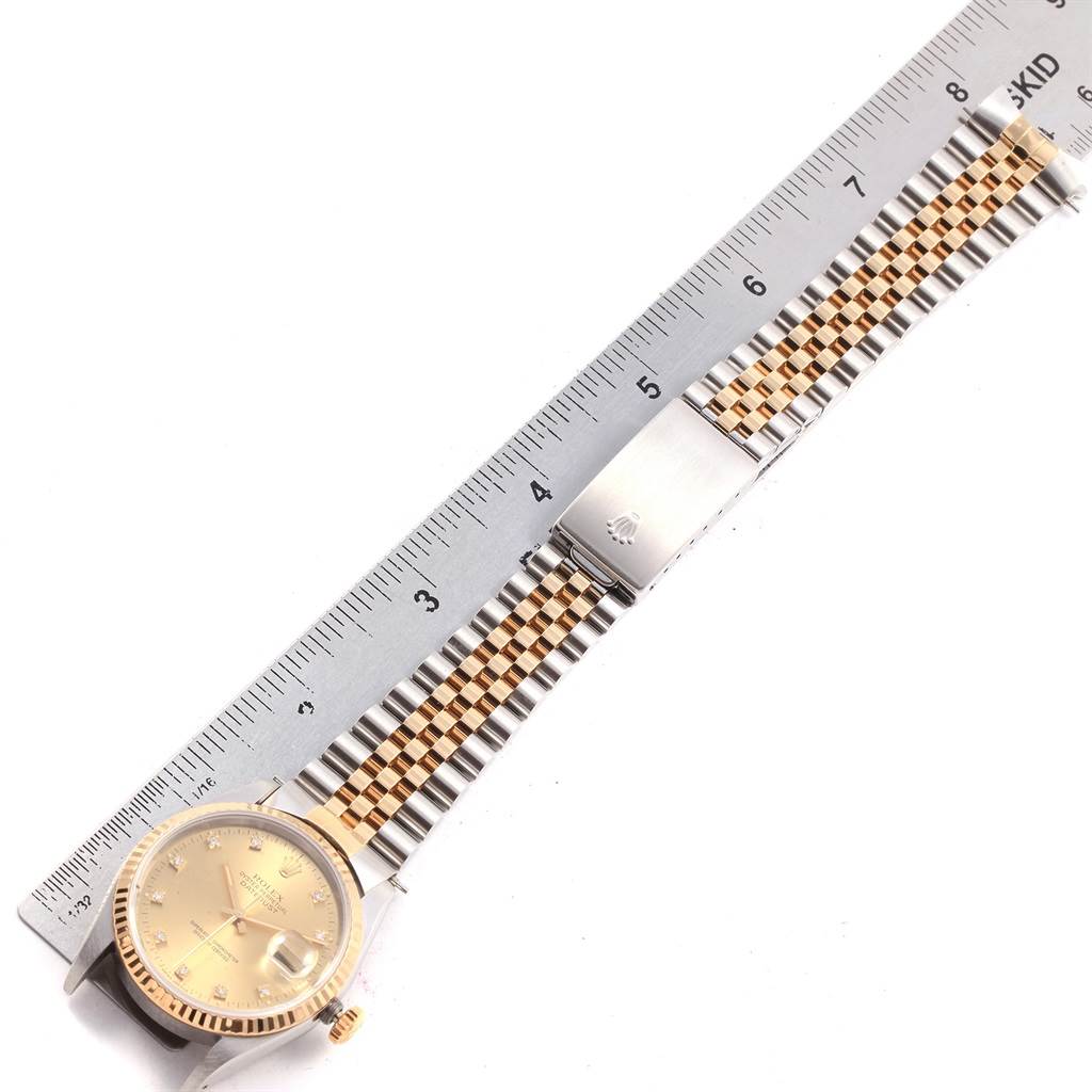 The image shows a Rolex Datejust 16233 Men's Steel and Gold (two tone) Champagne Dial 16233 Men's Steel and Gold (two tone) Champagne Dial watch laid flat, displaying the face, and two-tone bracelet, with a ruler for scale.