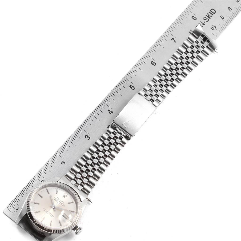 The image shows a Rolex Datejust 16234 Men's Stainless Steel Silver Dial 16234 Men's Stainless Steel Silver Dial watch laid flat with its band and clasp visible, alongside a ruler for measurement.