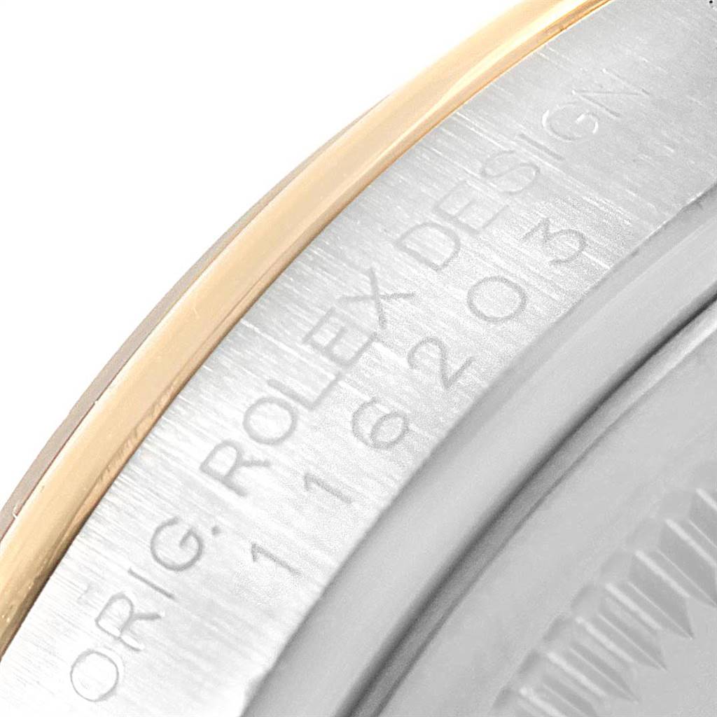 The image shows a close-up of the side of a Rolex Datejust 116203 Men's Stainless Steel Champagne Dial 116203 Men's Stainless Steel Champagne Dial watch, highlighting its bezel and part of the case with engraved text.