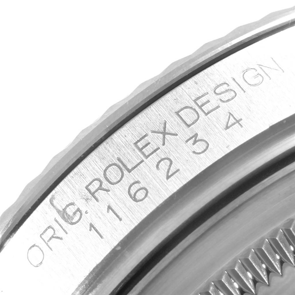 The image shows a close-up of the engraved bezel and case of a Rolex Datejust 116234 Men
s Stainless Steel White Dial 116234 Men
s Stainless Steel White Dial watch.