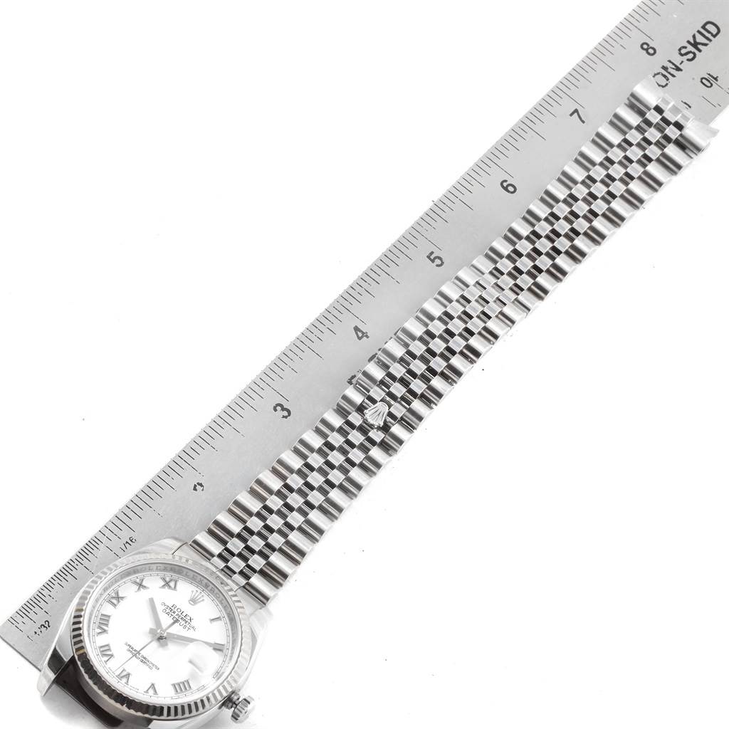 The image shows a Rolex Datejust 116234 Men
s Stainless Steel White Dial 116234 Men
s Stainless Steel White Dial watch laid flat with a metal ruler measuring its length.
