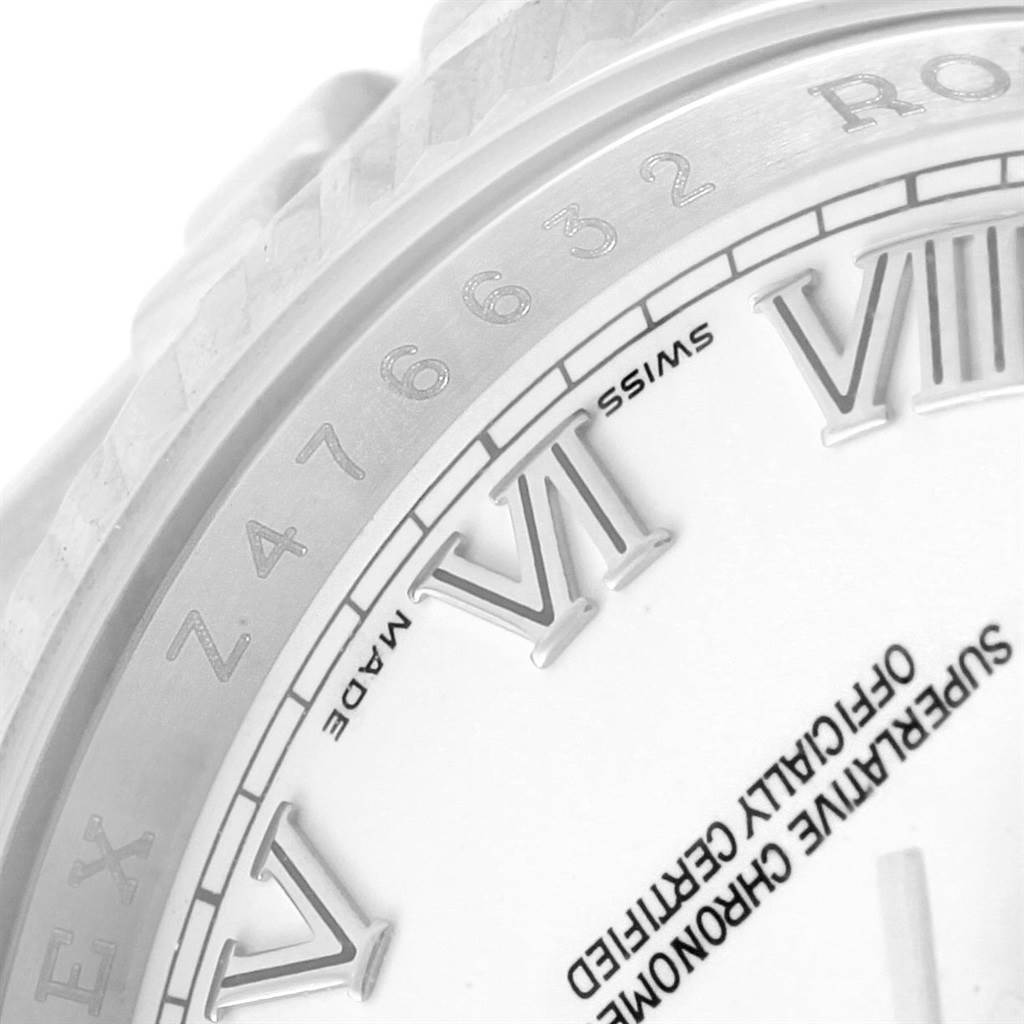 The image shows a close-up of a Rolex Datejust 116234 Men
s Stainless Steel White Dial 116234 Men
s Stainless Steel White Dial watch, highlighting part of the bezel, Roman numerals, and text around the dial.