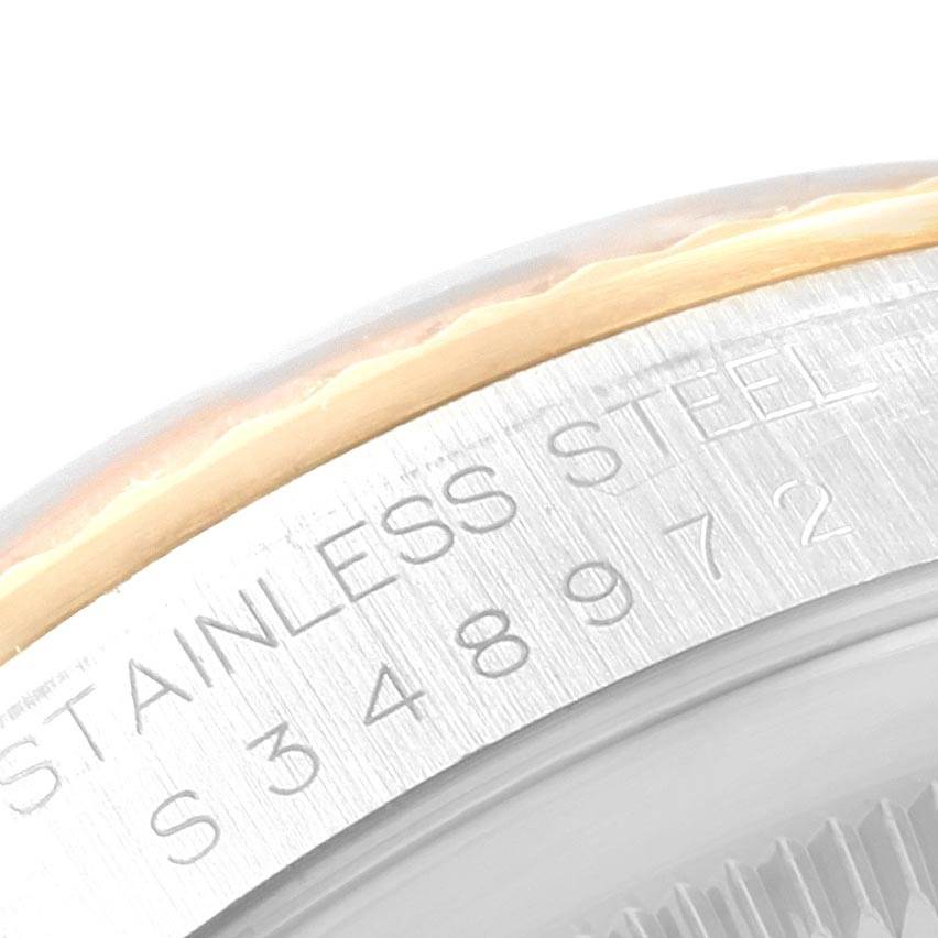 This image shows a close-up of the case side and serial number of a Rolex Datejust 16233 Men's Steel and Gold (two tone) Champagne Dial 16233 Men's Steel and Gold (two tone) Champagne Dial model, focusing on the stainless steel and gold rim.