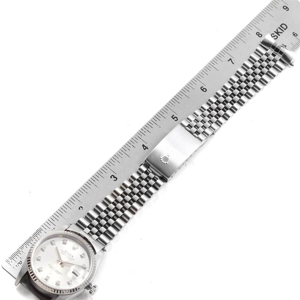 The image shows the Rolex Datejust 16234 Men
s Stainless Steel Silver Dial 16234 Men
s Stainless Steel Silver Dial watch, featuring the face, bracelet, and clasp, lying next to a ruler for scale.