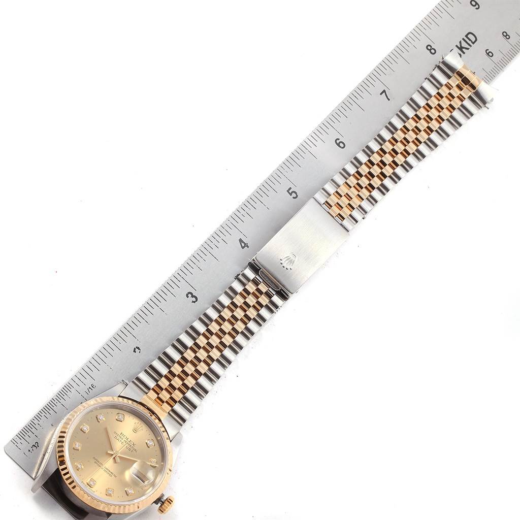 The image shows a Rolex Datejust 16233 Men's Steel and Gold (two tone) Champagne Dial 16233 Men's Steel and Gold (two tone) Champagne Dial watch laid flat next to a ruler, displaying the face and two-tone bracelet.