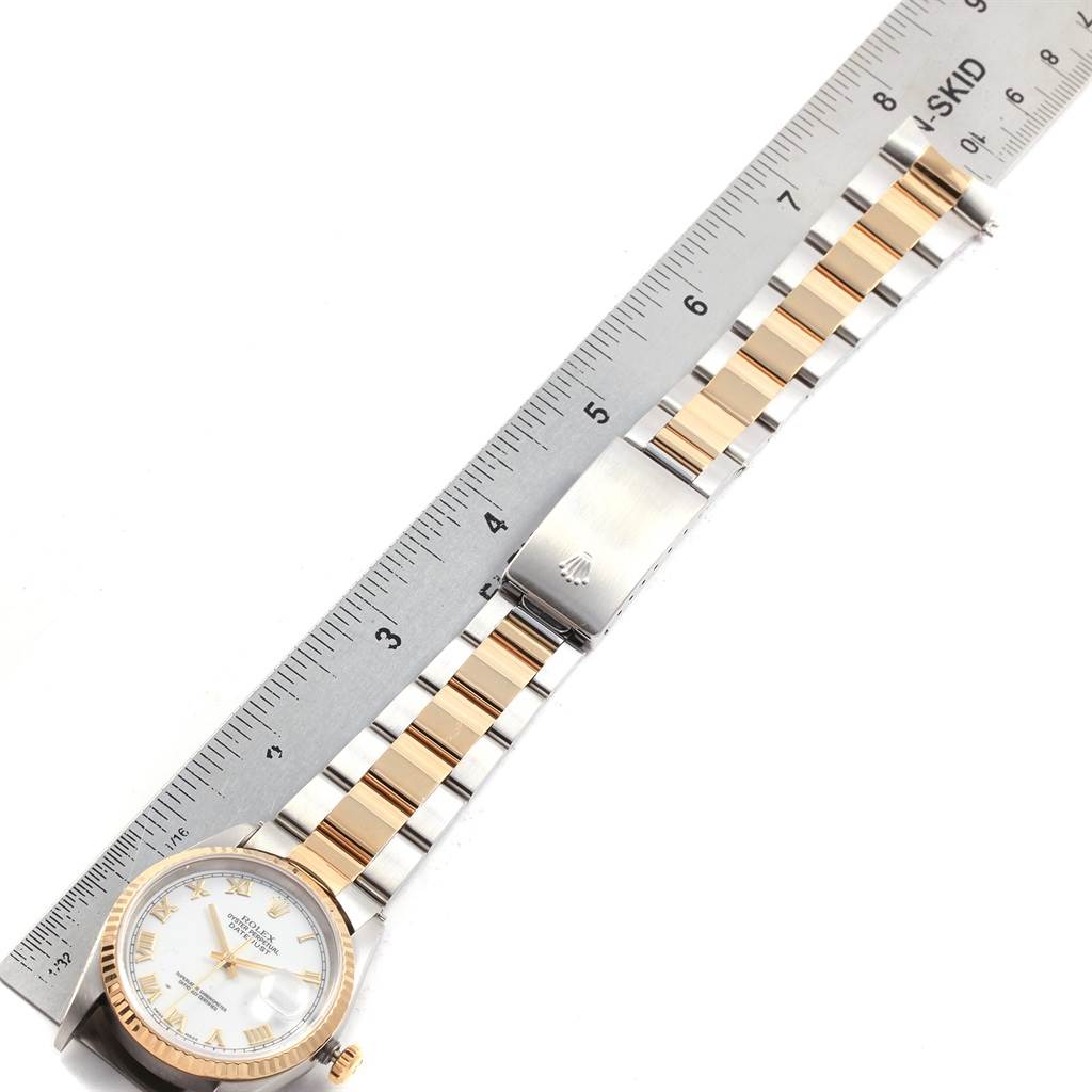 The Rolex Datejust 16233 Men's Steel and Gold (two tone) White Dial 16233 Men's Steel and Gold (two tone) White Dial watch is shown from a top-down angle, displaying the dial, bracelet, and clasp, with a ruler beside it for scale.