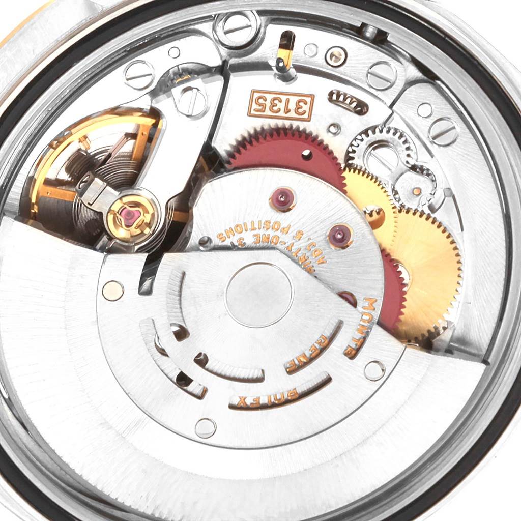 The image shows a close-up view of the movement inside a Rolex Datejust 16233 Men's Steel and Gold (two tone) White Dial 16233 Men's Steel and Gold (two tone) White Dial watch, highlighting its intricate gears and components.