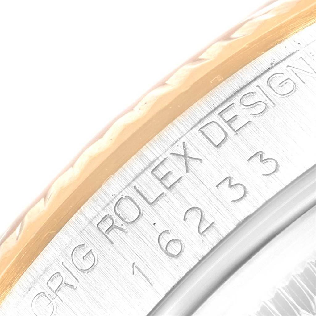 This close-up image shows the side of the bezel and case of a Rolex Datejust 16233 Men's Steel and Gold (two tone) Champagne Dial 16233 Men's Steel and Gold (two tone) Champagne Dial watch, displaying the model number and Rolex design engraving.