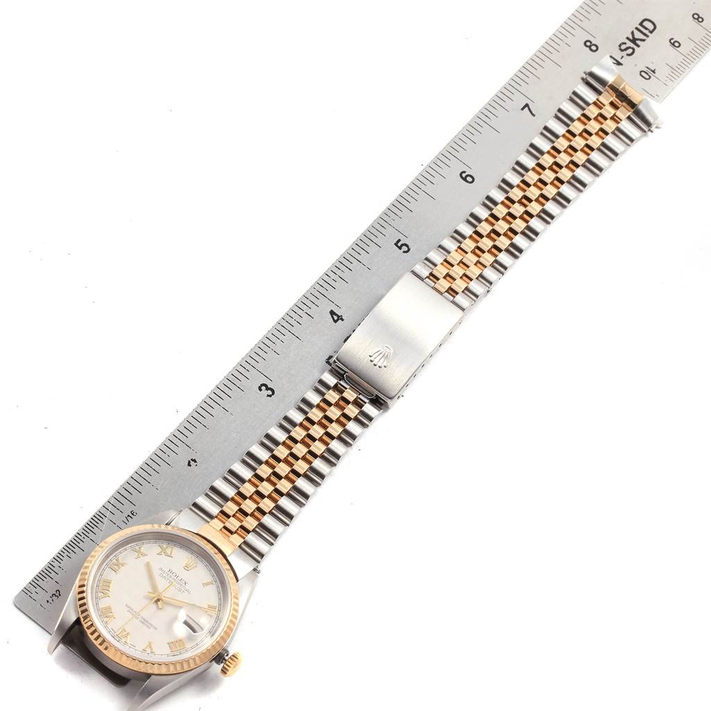 The Rolex Datejust 16233 Men's Steel and Gold (two tone) Beige Dial 16233 Men's Steel and Gold (two tone) Beige Dial watch is shown from a top-down angle, featuring its full face and bracelet alongside a ruler.