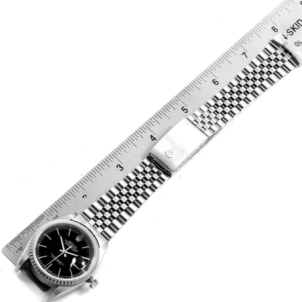 The image shows the face and metal band of a Rolex Datejust 16220 Men
s Stainless Steel Black Dial 16220 Men
s Stainless Steel Black Dial watch, aligned with a ruler for size measurement.