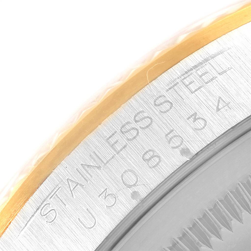 This image shows a close-up of the side and edge of the bezel of a Rolex Datejust 16233 Men
s Steel and Gold (two tone) Champagne Dial 16233 Men
s Steel and Gold (two tone) Champagne Dial watch, featuring the "STAINLESS STEEL" engraving.
