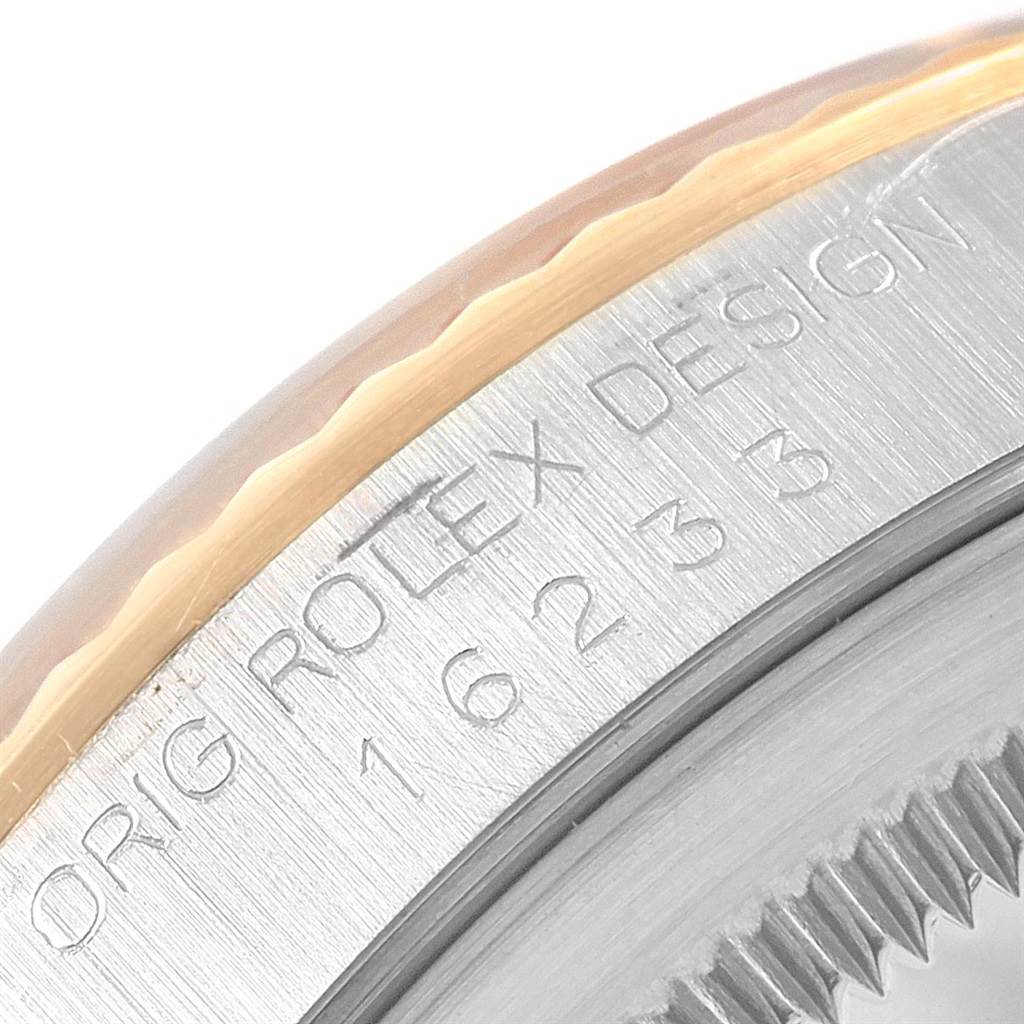 This close-up image shows the engraved side and fluted bezel of a Rolex Datejust 16233 Men
s Steel and Gold (two tone) Beige Dial 16233 Men
s Steel and Gold (two tone) Beige Dial watch.